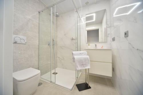 贝尼多姆Luksusowy Apartament Sunset Cliffs Benidorm的带淋浴和卫生间的白色浴室