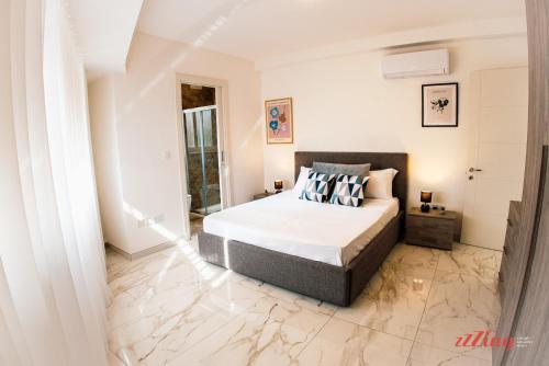圣朱利安斯Mensija Valley Residences的一间铺有大理石地板的卧室,配有一张床