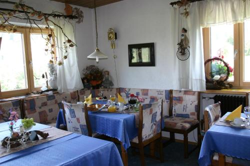 申贝格霍伊思旅馆的一间用餐室,配有两张带蓝桌布的桌子