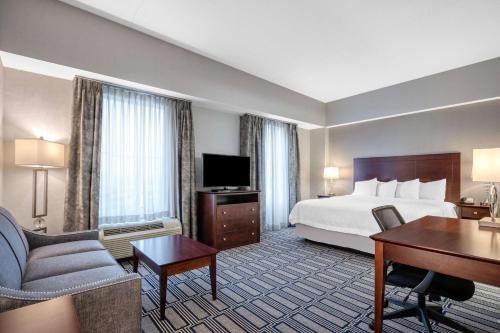 普罗维登斯普罗维斯登市中心希尔顿恒庭旅馆&套房酒店的酒店客房配有一张特大号床和一张书桌