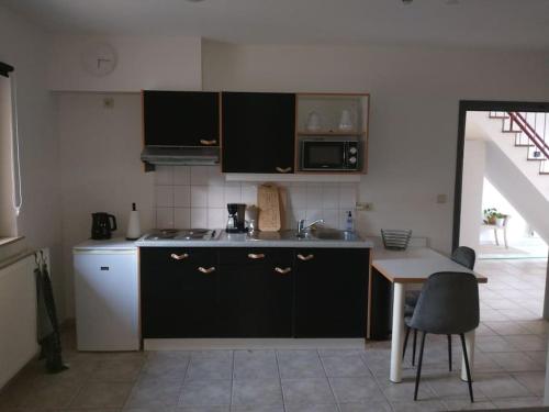 里姆斯特De Millenniumhoeve (Jean)的厨房配有黑色橱柜、桌子和水槽。