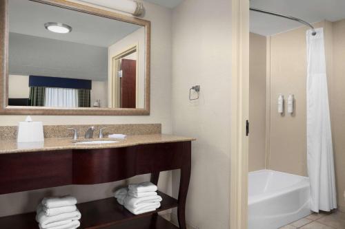 利物浦西拉丘兹克莱汉普顿酒店的一间带水槽、浴缸和镜子的浴室