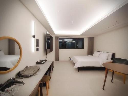 仁川市인천 연수 블루버드호텔 Bluebird Hotel的酒店客房,设有两张床和镜子
