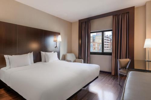 萨莫拉萨莫拉生活方式万豪AC酒店的酒店客房设有一张白色大床和一个窗户。