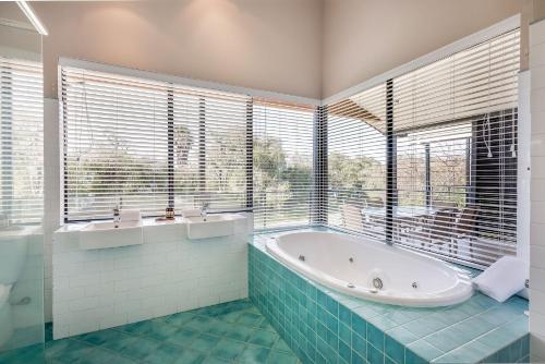 邓斯伯勒丽晶海滩俱乐部酒店的带浴缸的浴室和大窗户