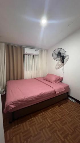 MabalacatOrilla Transient 1的卧室配有粉红色的床和风扇。