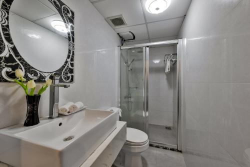 吉婆岛吉婆岛中央2号酒店 的一间带水槽、淋浴和镜子的浴室