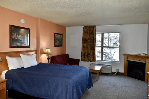 鸽子谷Grand Smokies Resort Lodge Pigeon Forge的酒店客房配有一张床和一个壁炉。