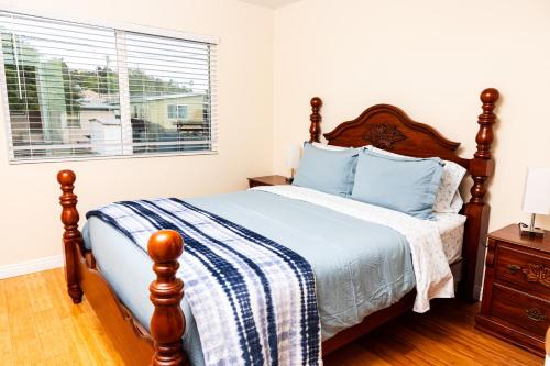 圣地亚哥2BR Retreat w/ Balcony Views in Central San Diego!的一间卧室配有一张带蓝色枕头的床和一扇窗户。