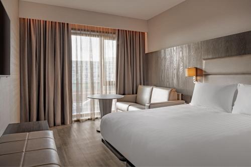 曼彻斯特AC Hotel by Marriott Manchester City Centre的酒店的客房 - 带一张床、椅子和窗户