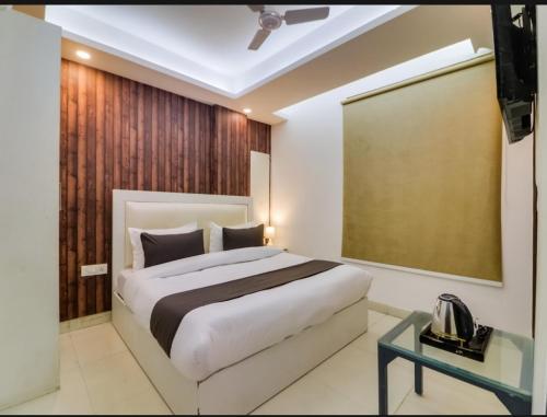 新德里Hotel Galaxy Stay B&B的一间卧室设有一张大床和一张玻璃桌