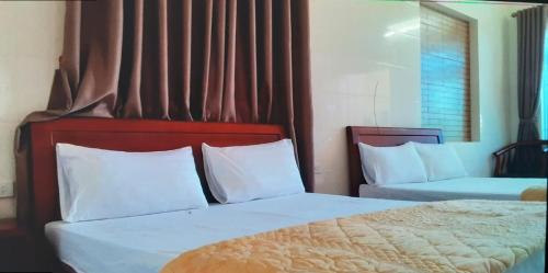 Ngô XaNhà nghỉ Thanh Bình的一间卧室配有两张带白色枕头的床