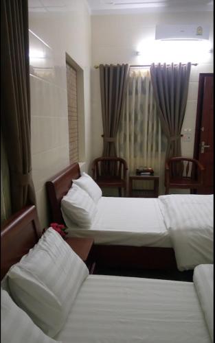 Ngô XaNhà nghỉ Thanh Bình的酒店客房,配有两张床和两把椅子