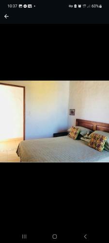 San CarlosSan Carlos beach in的一间卧室配有带两个枕头的床和窗户