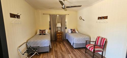 Glendon Brook金合欢旅舍的一间卧室配有两张床和吊扇