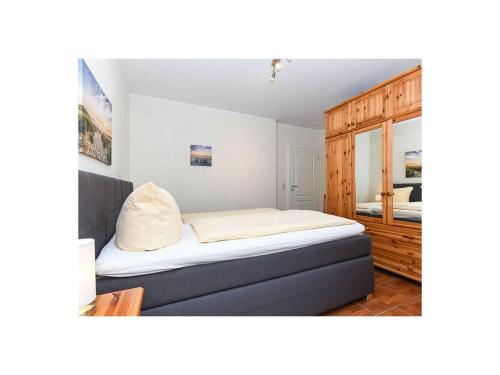 贝塞尔Friesengold Modern retreat的一间卧室配有一张床和一个木制橱柜