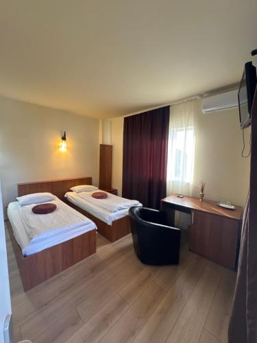 德罗贝塔-塞维林堡Pensiunea Drobeta的酒店客房,配有两张床和椅子