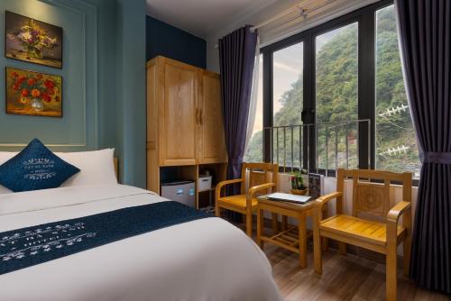 吉婆岛Cat Ba Xanh Spring Garden Hotel的一间卧室配有床、椅子和窗户