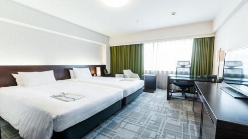 鹿儿岛鹿儿岛天文馆里士满酒店的酒店客房设有一张大床和一张书桌。