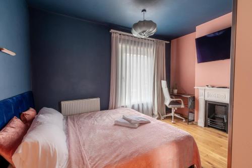 米尔顿凯恩斯Milton Keynes Cosy Guest House的一间卧室配有一张床、一张桌子和一把椅子
