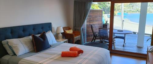 但尼丁New luxury waterfront accommodation的一间卧室配有一张带橙色枕头的床