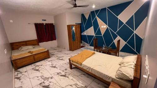 BhāgamandalaLucky star hotel的一间卧室设有两张床和蓝色的墙壁
