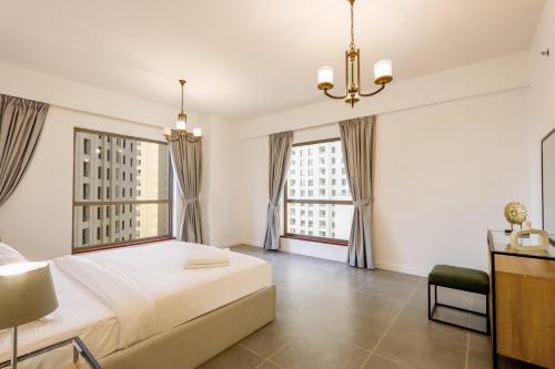 迪拜Livbnb- Homely 3+1 in Heart of JBR, Close to Beach的一间卧室设有一张床和两个大窗户