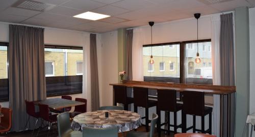 哥德堡Hostel Snoozemore的一间带酒吧、桌子和椅子的用餐室