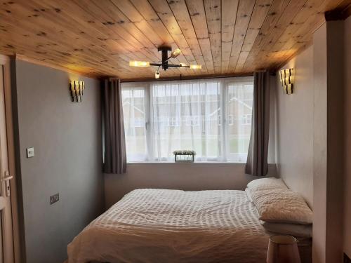 米尔登霍尔Mildenhall Suffolk的一间卧室设有一张木天花板床。