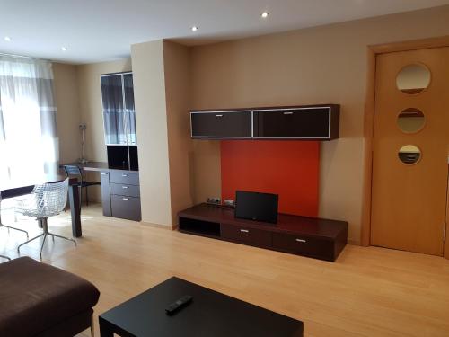曼雷沙Pis de bon disseny i sostenible.的客厅配有沙发和墙上的电视