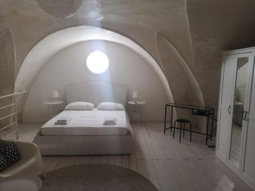 卡萨拉诺loft corte pisanelli的卧室配有白色的床和圆形窗户。