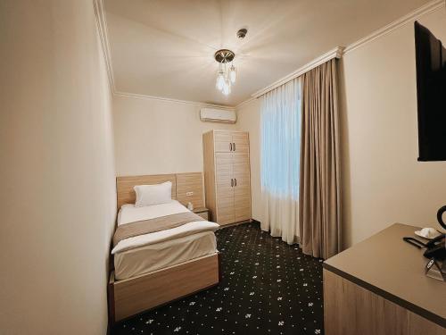 埃里温Colette Hotel的小房间设有两张床和一张书桌