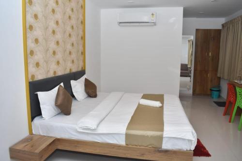 奥兰加巴德Hotel Karan International ,Aurangabad的一间卧室配有带白色床单和枕头的床。