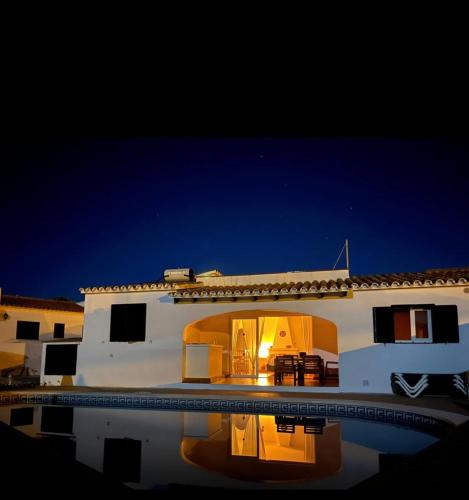 卡拉恩波特Villa Coral的白色的房子,晚上设有游泳池