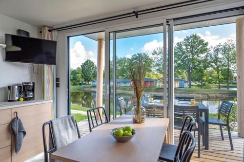 恩斯赫德Vakantiepark Vlinderloo的厨房以及带桌子和大窗户的用餐室。