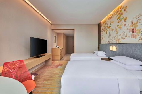 苏州苏州吴中希尔顿花园酒店的酒店客房设有两张床和一台平面电视。