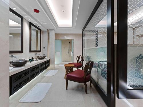 阿布扎比Rixos Marina Abu Dhabi的浴室配有水槽和带2把椅子的梳妆台。