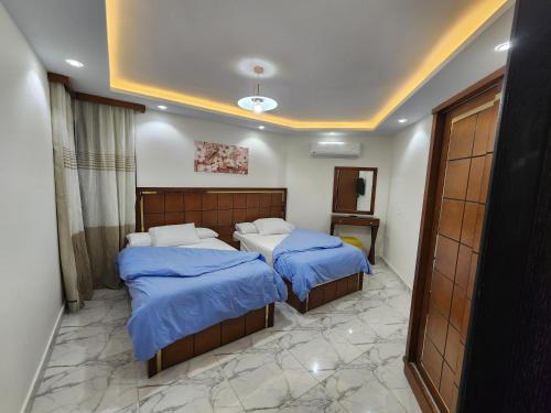 塞得港Porto said بورتوسعيد غرفتين وصاله的一间卧室配有两张带蓝色棉被的床