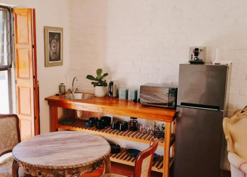 里比克堡Olyfenhuis的厨房配有木桌和冰箱。