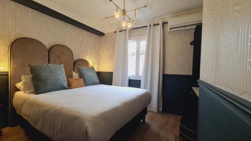 普罗旺斯艾克斯快帆酒店的卧室配有一张带吊灯的大型白色床。