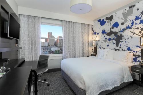 旧金山旧金山联合广场万怡酒店的配有一张床、一张书桌和一扇窗户的酒店客房