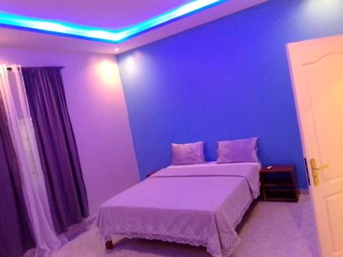 姆布尔Villa Fama的一间卧室配有一张蓝色墙壁的床