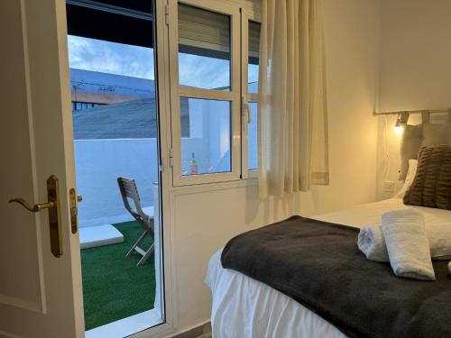 塞维利亚Casa Boutique Plaza de Armas -Townhouse-的一间卧室设有一张床和一个美景窗户。