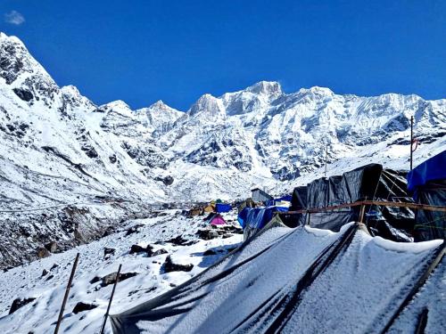 KedārnāthRajwan peradise tents的雪覆盖的山间,有一组帐篷