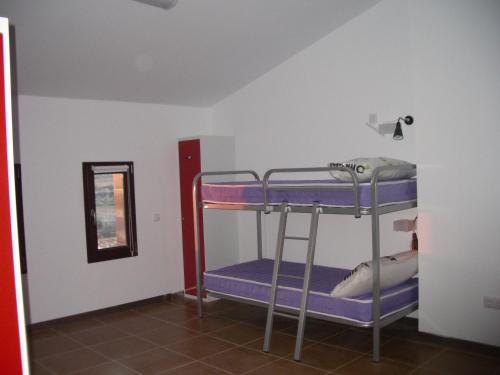 AniñonHostel El Castillo的客房设有两张双层床和镜子