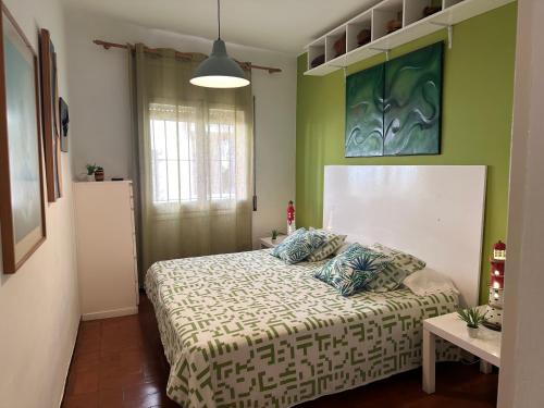 帕拉莫斯Apartamento con jardín a 11 metros de la playa. B3.的一间设有床铺的卧室,位于一个拥有绿色墙壁的房间