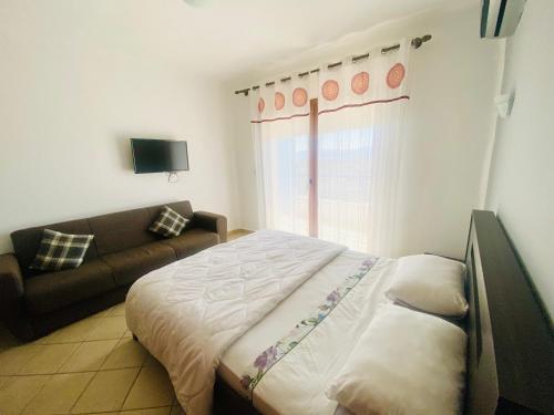 卡博尼格洛Cabo Dream Apparthotel的一间卧室配有一张床和一张沙发