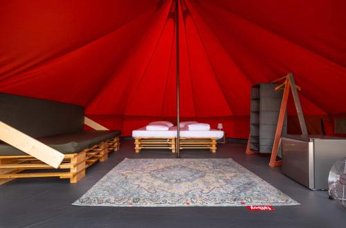 法鲁Glamping Camp Faro的红色帐篷 - 带两张床和地毯
