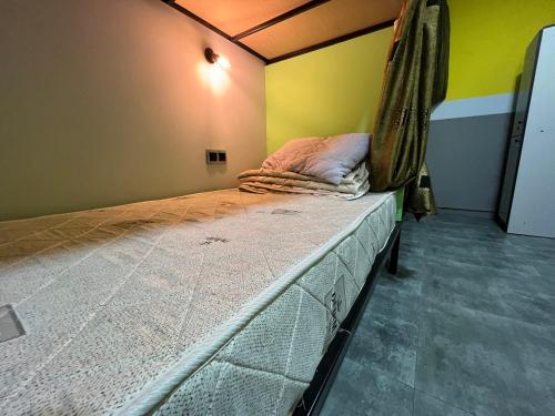 阿拉木图Fox Fort Hostel的卧室配有一张床铺,位于一个黄色墙壁的房间