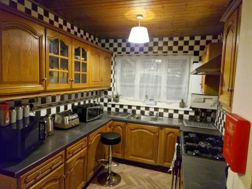 BuckinghamshireSteyn Guest Lodge的厨房配有木制橱柜和黑白瓷砖